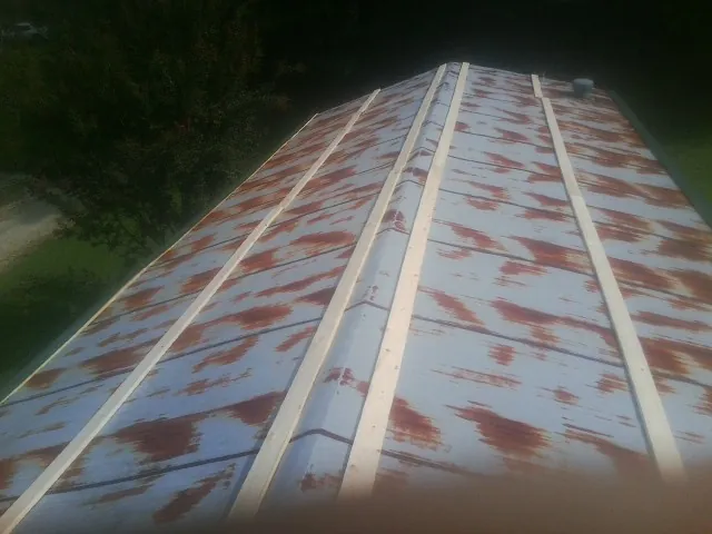 Rusted metal roof panels with new wood purlins before replacement — Storm Damage Roof Repair in Condon by Roofing Brothers