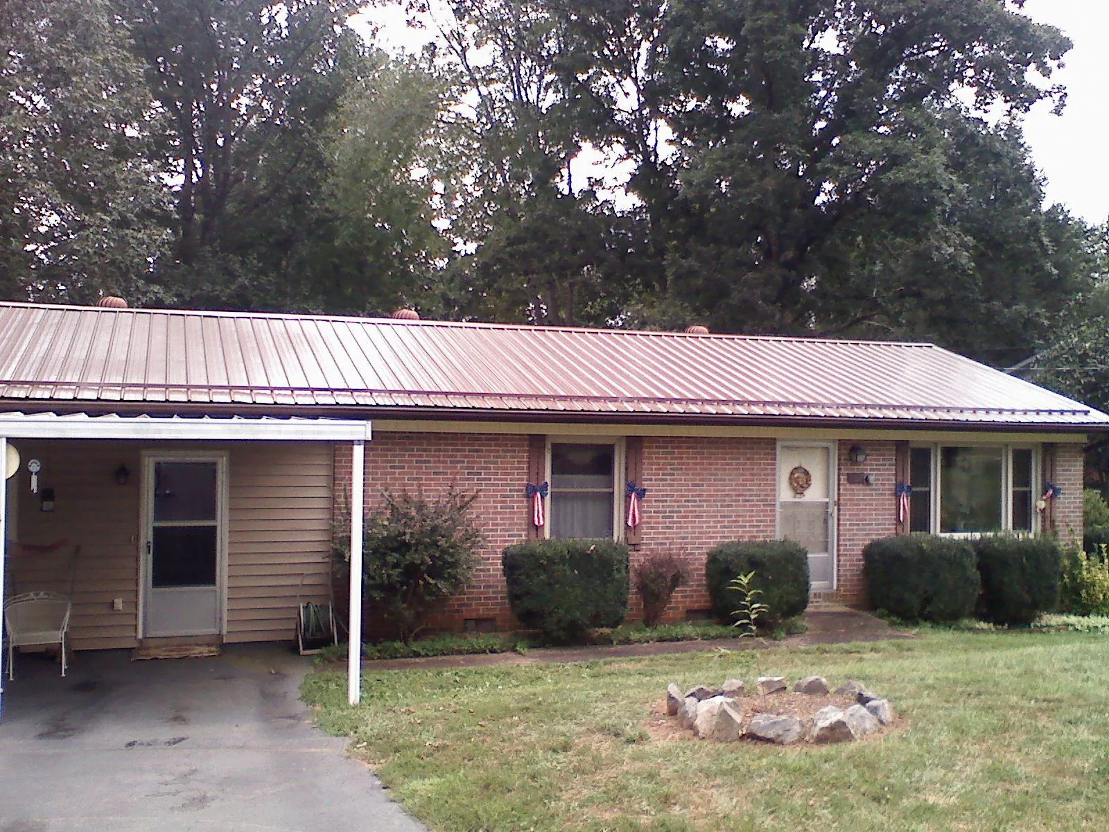 Bronze metal roof and carport on a brick ranch home — Roof Repair work by our crew in Condon